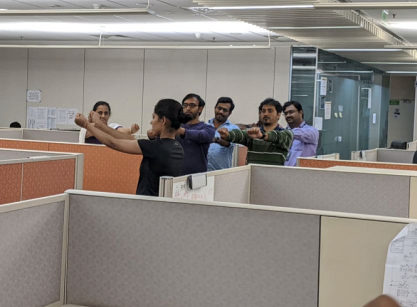 Office workers doing stretching exercises in cubicles